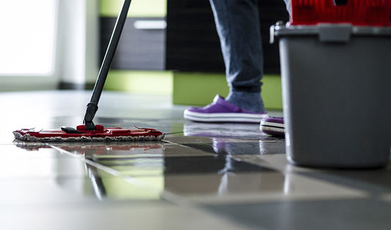 A person is cleaning the floor with a mop.